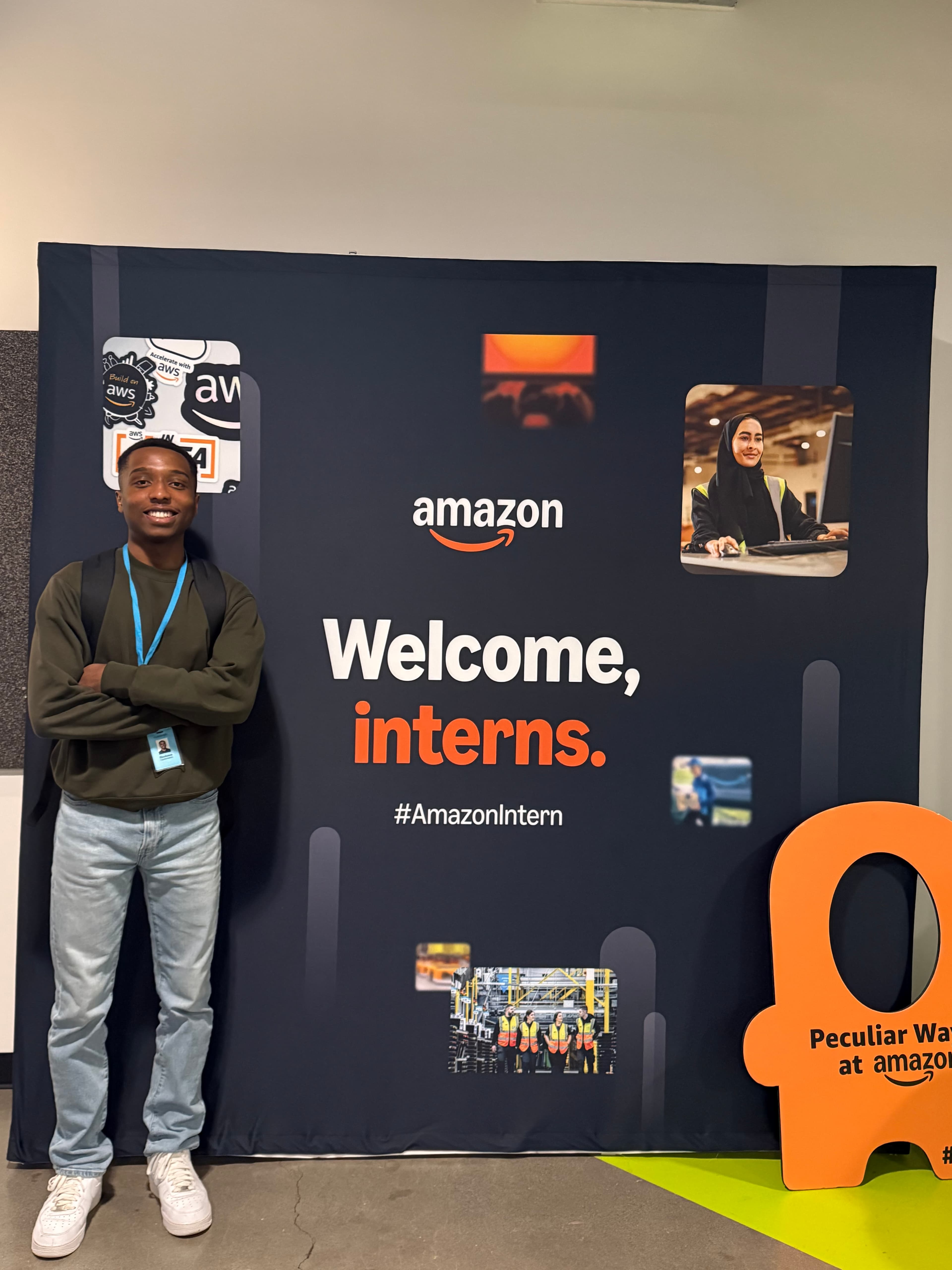 A person standing beside an Amazon welcome interns display